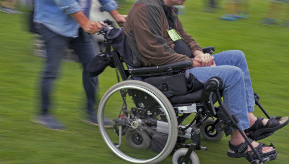 Mand bliver kørt i kørestol